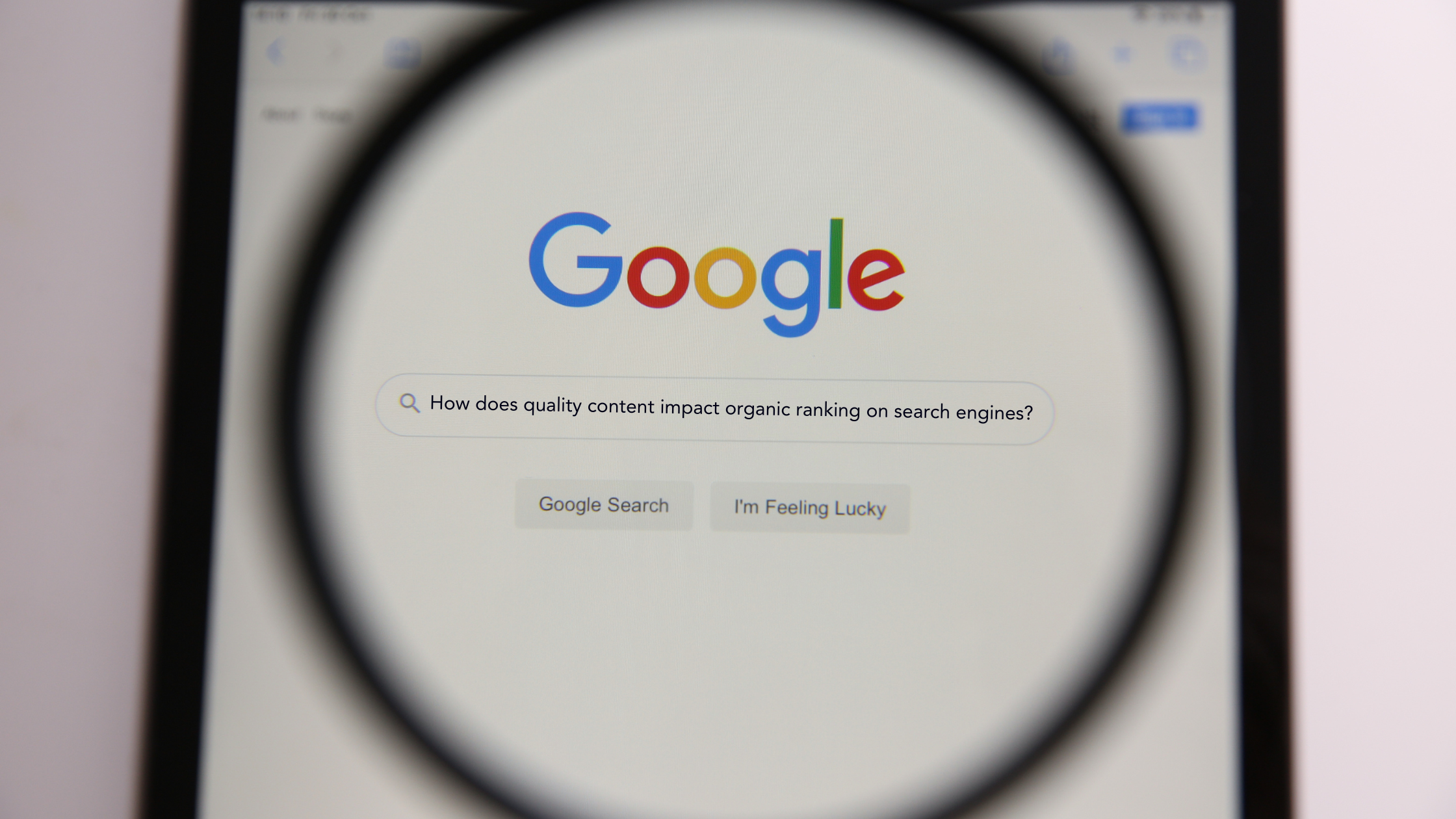 Image of magnified Google search page with the question “How does quality content impact organic ranking on search engines?”